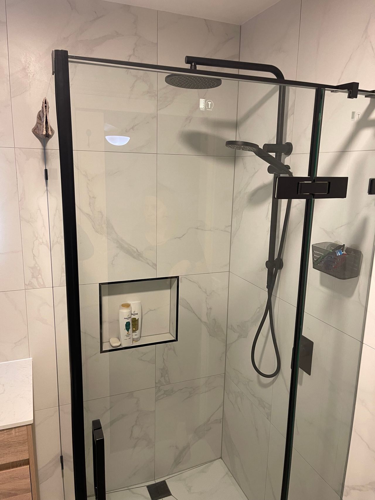 Black-framed hinged shower screen with twin shower rail and recessed niche in Cranbourne North