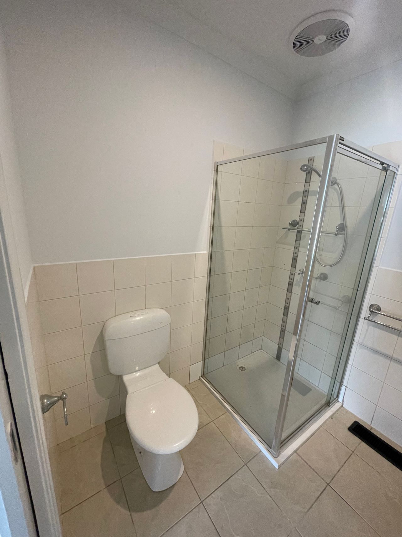 Before: original shower and toilet in a Mitcham bathroom, with half-height cream wall tiles