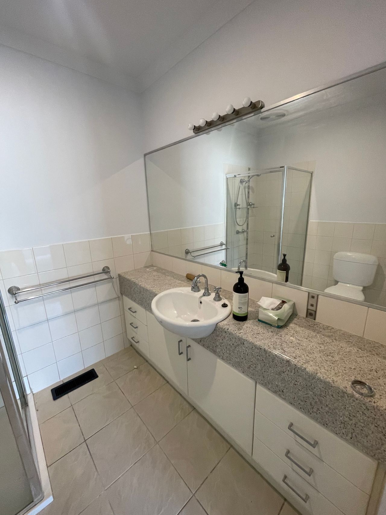 Before: original vanity in a Mitcham bathroom with a speckled laminate top and large wall mirror