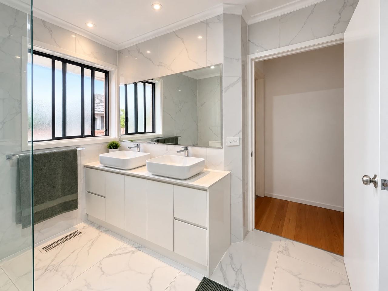 Renovated bathroom in Noble Park with a double vanity, twin vessel basins and marble-look tiles