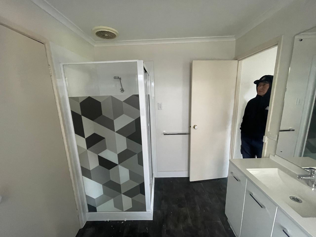Before: Rowville bathroom with a framed shower, geometric feature tiles and a dark tiled floor